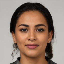 Joyful latino young-adult female with medium  brown hair and brown eyes