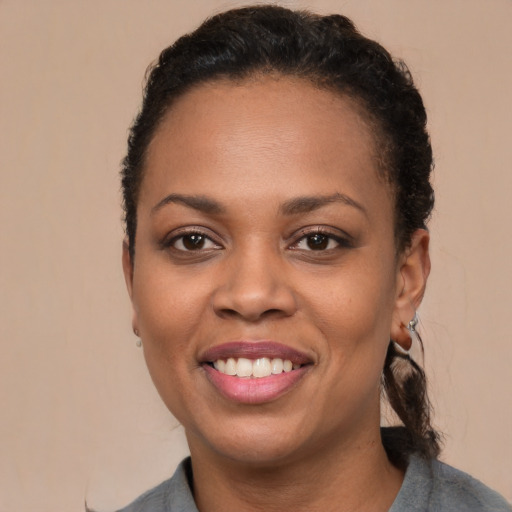 Joyful black young-adult female with short  brown hair and brown eyes
