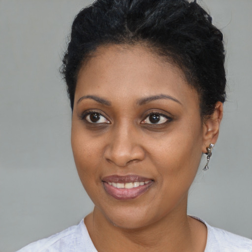 Joyful black young-adult female with short  brown hair and brown eyes
