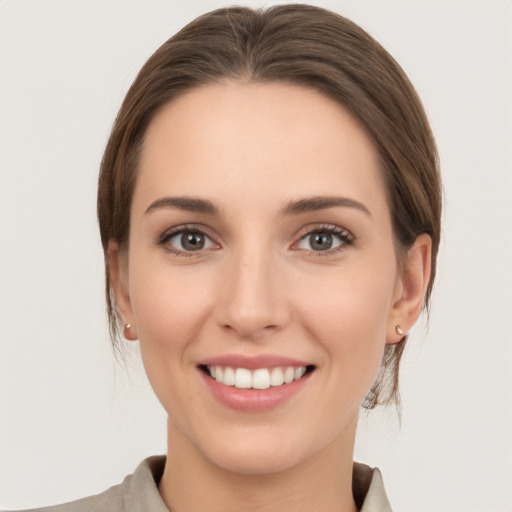 Joyful white young-adult female with medium  brown hair and grey eyes