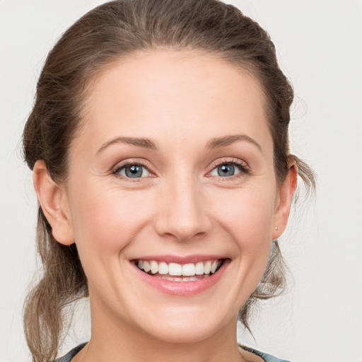 Joyful white young-adult female with medium  brown hair and grey eyes