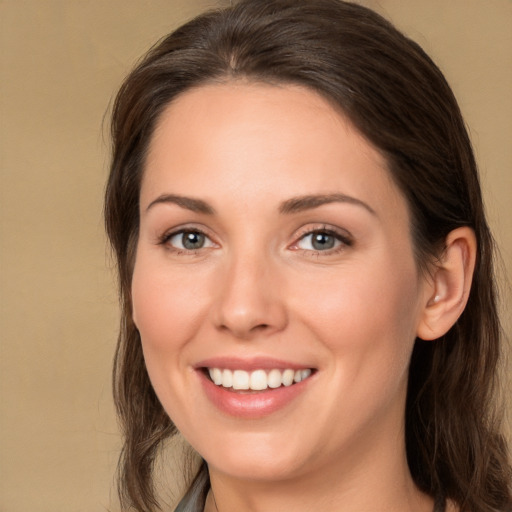 Joyful white young-adult female with long  brown hair and brown eyes