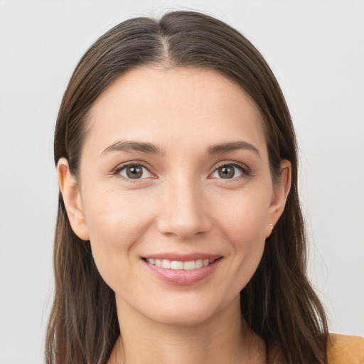 Joyful white young-adult female with long  brown hair and brown eyes