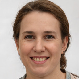 Joyful white adult female with medium  brown hair and grey eyes