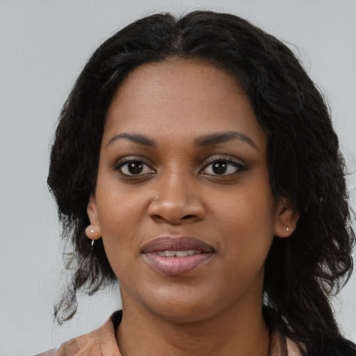 Joyful black young-adult female with long  black hair and brown eyes