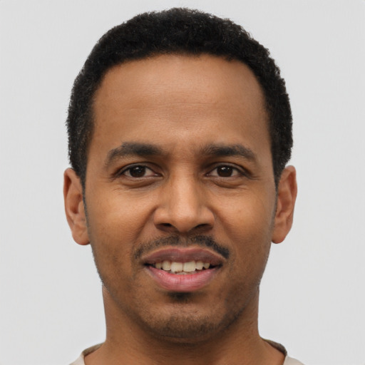 Joyful black young-adult male with short  black hair and brown eyes