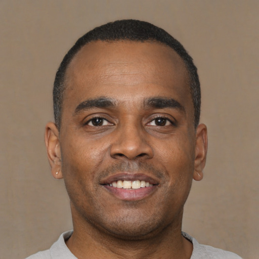 Joyful latino young-adult male with short  brown hair and brown eyes