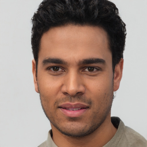 Joyful latino young-adult male with short  black hair and brown eyes