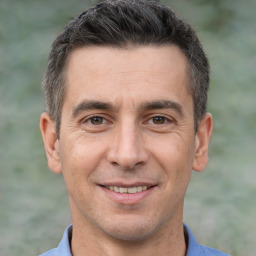 Joyful white adult male with short  brown hair and brown eyes