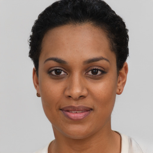 Joyful black young-adult female with short  black hair and brown eyes