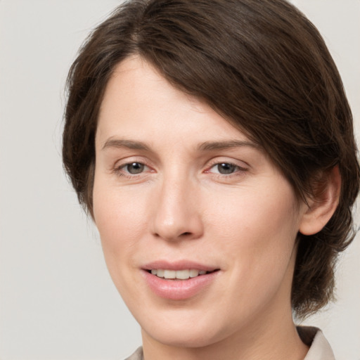 Joyful white young-adult female with medium  brown hair and grey eyes