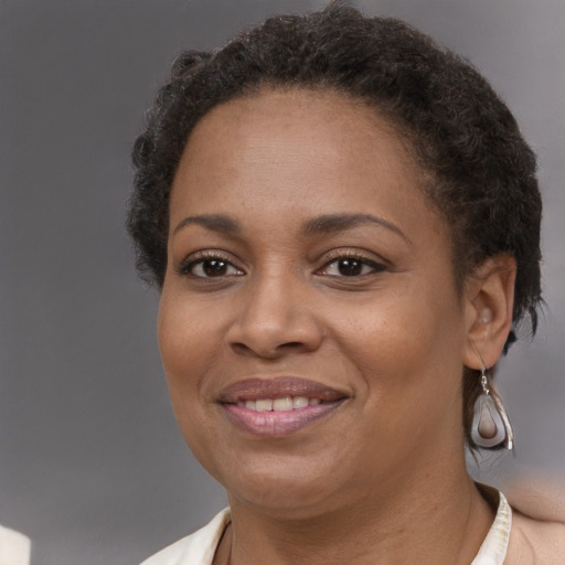 Joyful black adult female with short  brown hair and brown eyes