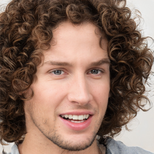 Joyful white young-adult male with medium  brown hair and green eyes