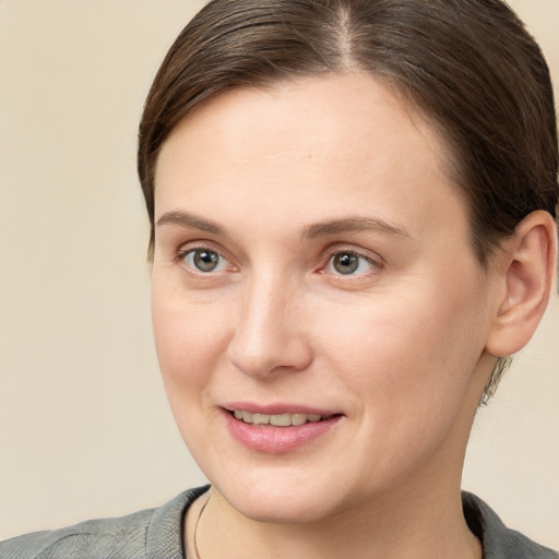 Joyful white young-adult female with short  brown hair and grey eyes