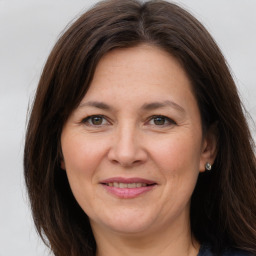 Joyful white adult female with long  brown hair and brown eyes