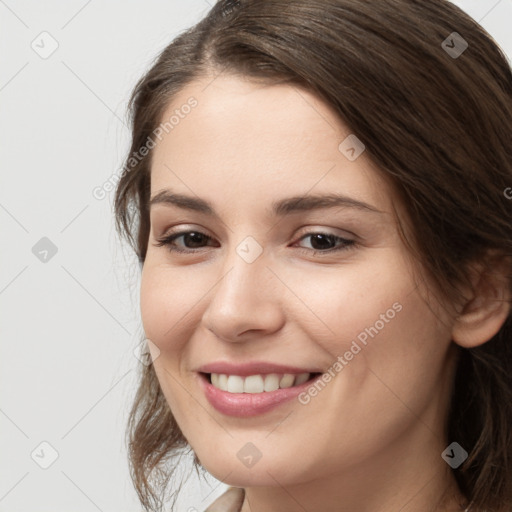 Joyful white young-adult female with long  brown hair and brown eyes