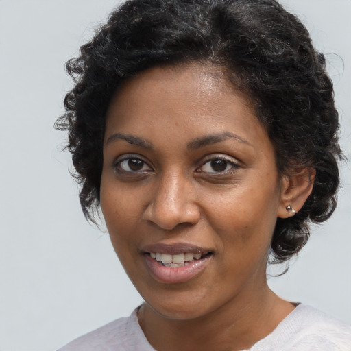 Joyful black young-adult female with short  brown hair and brown eyes