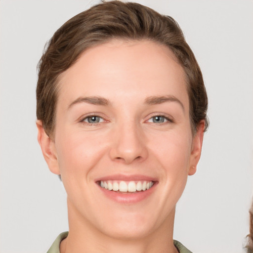 Joyful white young-adult female with short  brown hair and grey eyes