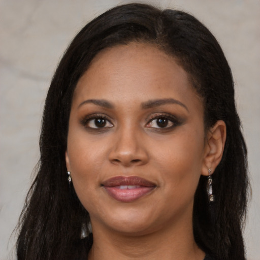 Joyful black young-adult female with long  brown hair and brown eyes