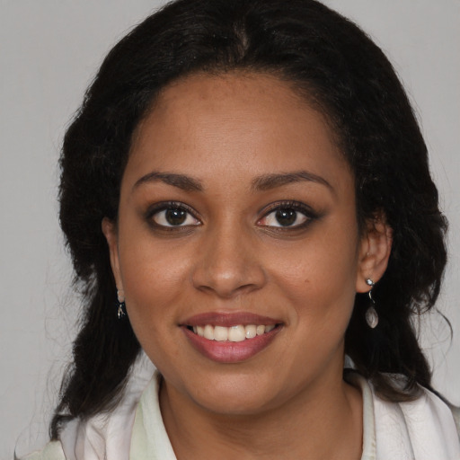 Joyful black young-adult female with long  brown hair and brown eyes