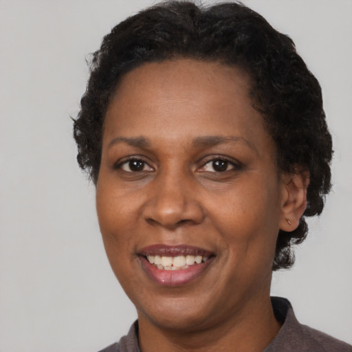 Joyful black adult female with short  brown hair and brown eyes