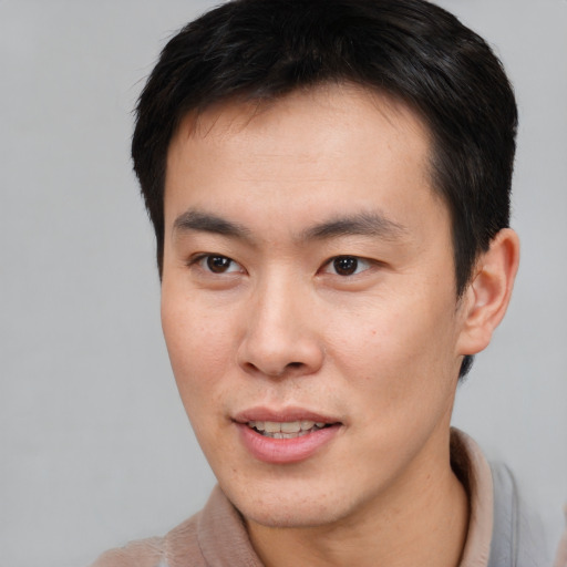 Joyful asian young-adult male with short  brown hair and brown eyes