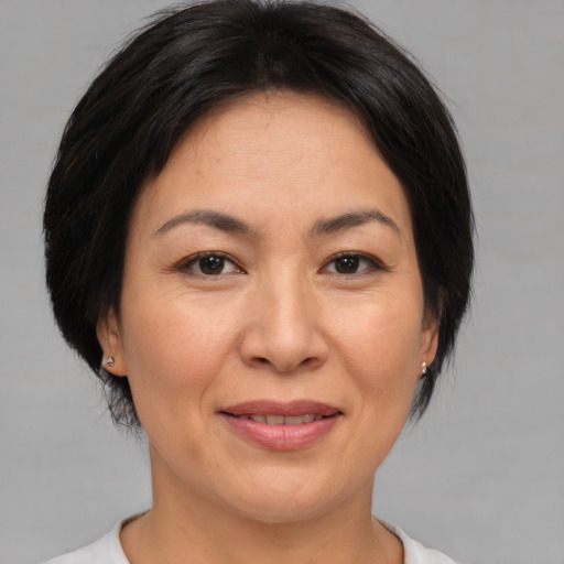 Joyful asian adult female with medium  brown hair and brown eyes