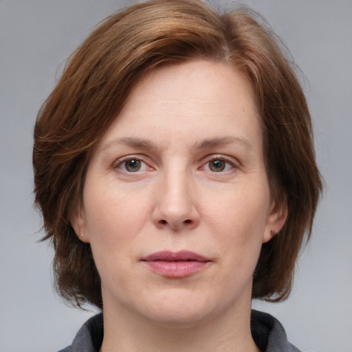 Joyful white adult female with medium  brown hair and grey eyes