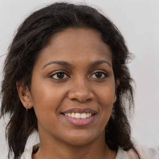 Joyful black young-adult female with medium  brown hair and brown eyes