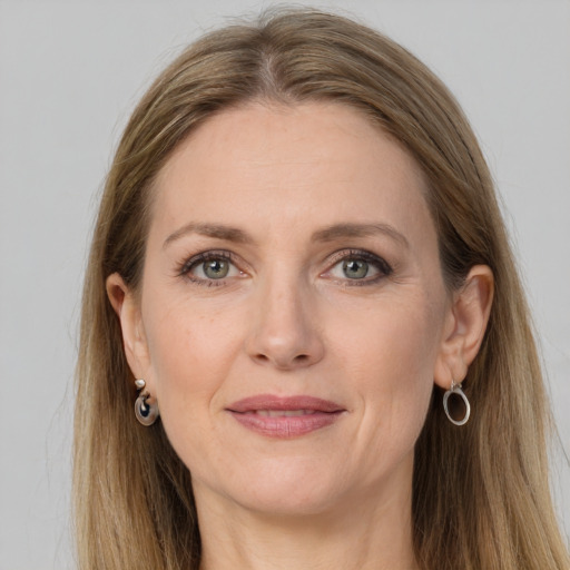 Joyful white adult female with long  brown hair and grey eyes