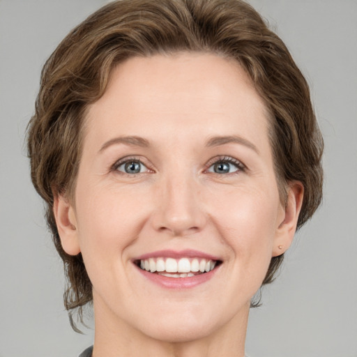 Joyful white adult female with medium  brown hair and green eyes