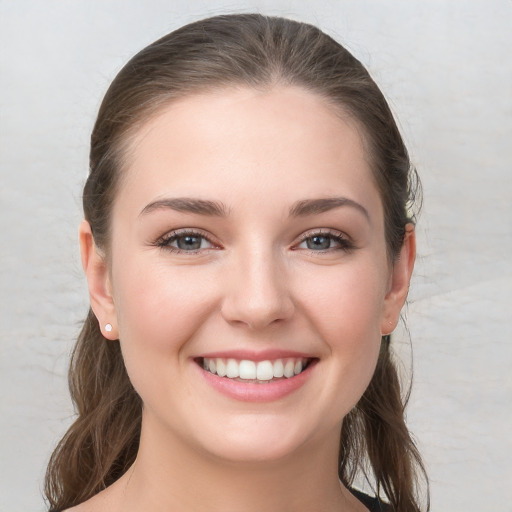 Joyful white young-adult female with long  brown hair and grey eyes