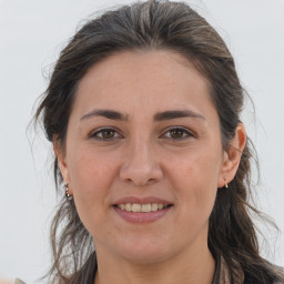 Joyful white adult female with long  brown hair and brown eyes