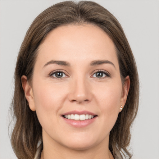 Joyful white young-adult female with medium  brown hair and grey eyes