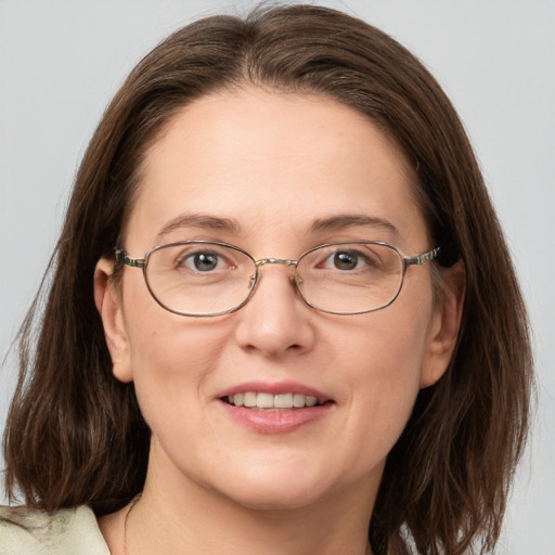 Joyful white adult female with medium  brown hair and grey eyes