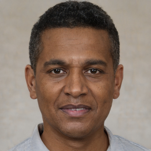 Joyful black adult male with short  brown hair and brown eyes