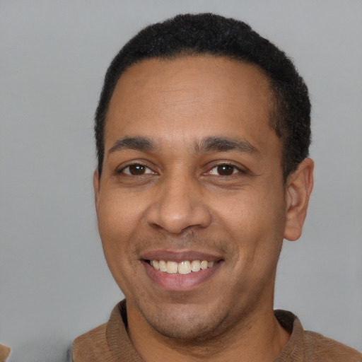 Joyful latino young-adult male with short  brown hair and brown eyes