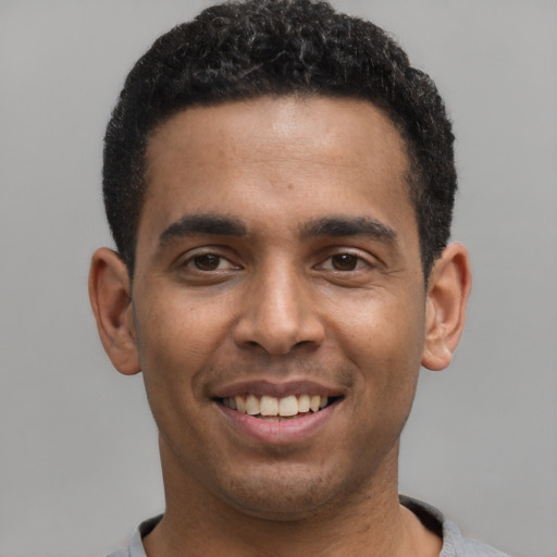 Joyful latino young-adult male with short  black hair and brown eyes