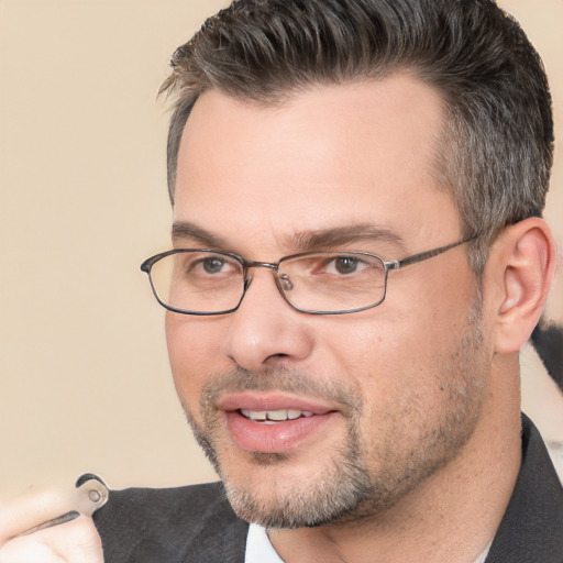 Joyful white adult male with short  black hair and brown eyes