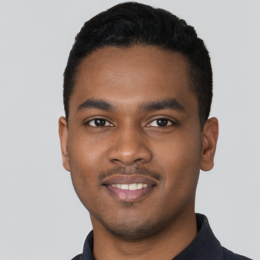 Joyful black young-adult male with short  black hair and brown eyes