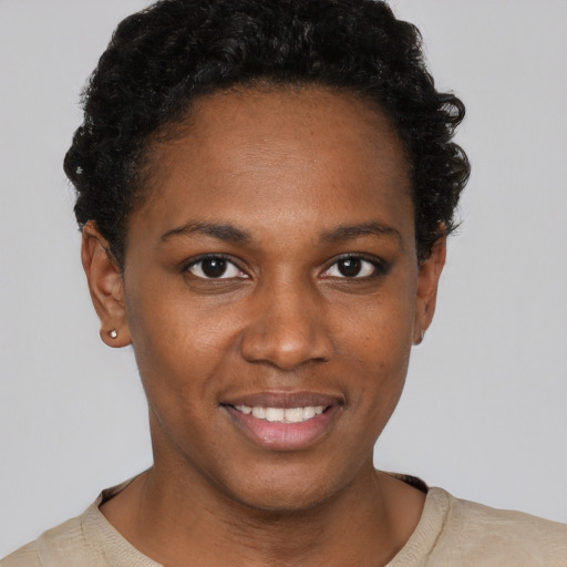 Joyful black young-adult female with short  brown hair and brown eyes
