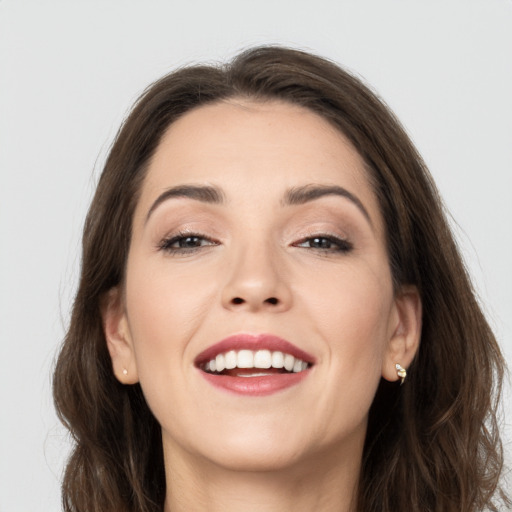 Joyful white young-adult female with long  brown hair and brown eyes