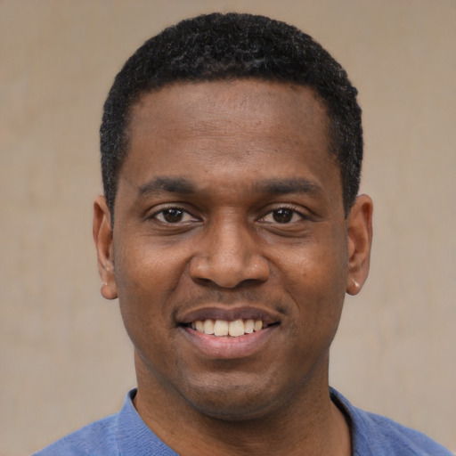 Joyful black young-adult male with short  black hair and brown eyes