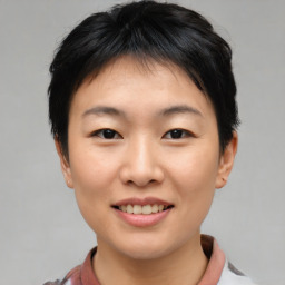 Joyful asian young-adult female with short  brown hair and brown eyes