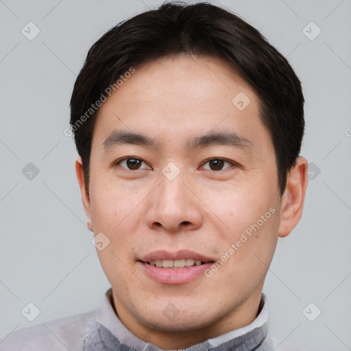 Joyful asian young-adult male with short  brown hair and brown eyes