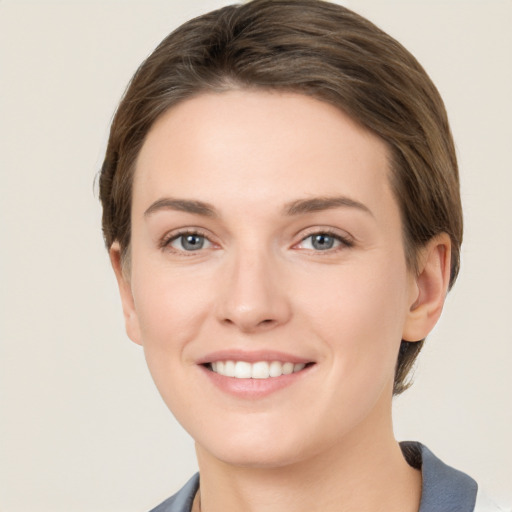 Joyful white young-adult female with short  brown hair and grey eyes