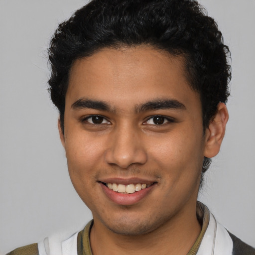 Joyful latino young-adult male with short  brown hair and brown eyes