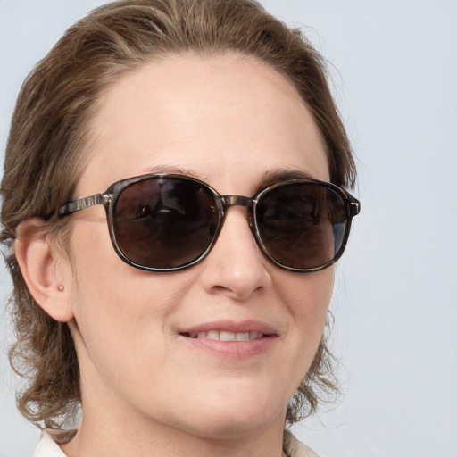 Joyful white young-adult female with medium  brown hair and blue eyes