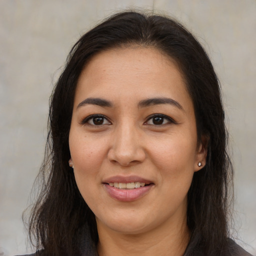 Joyful latino adult female with long  brown hair and brown eyes