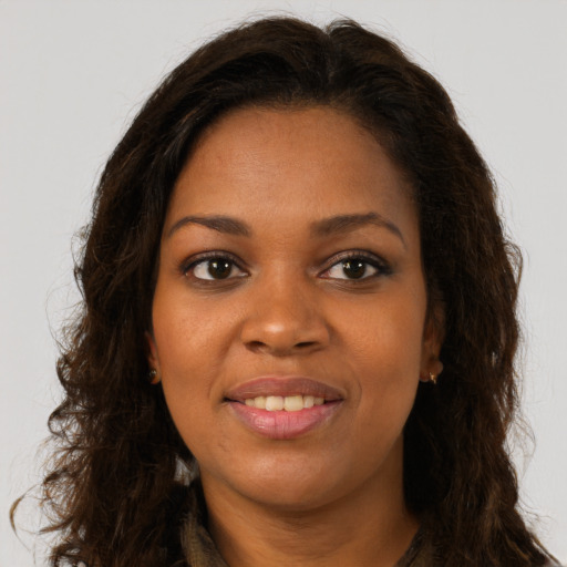 Joyful black young-adult female with long  brown hair and brown eyes
